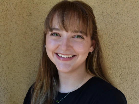 Headshot image of graduate student in front of beige wall.