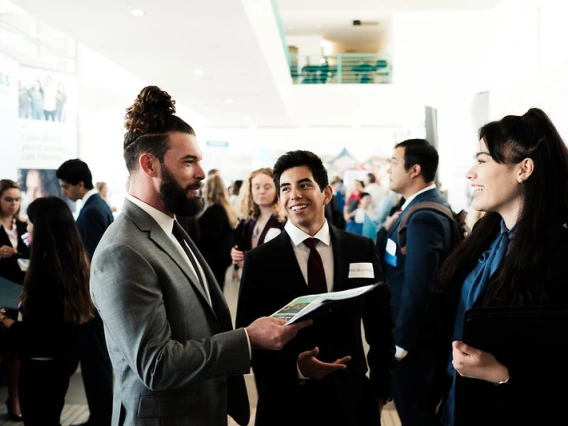 Students wearing business formal attire networking at an event.