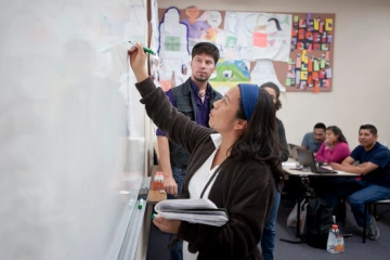 Student at White Board in UA Classroom