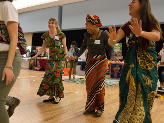 Fellows dancing in African traditional clothing at Peace Corps Fair