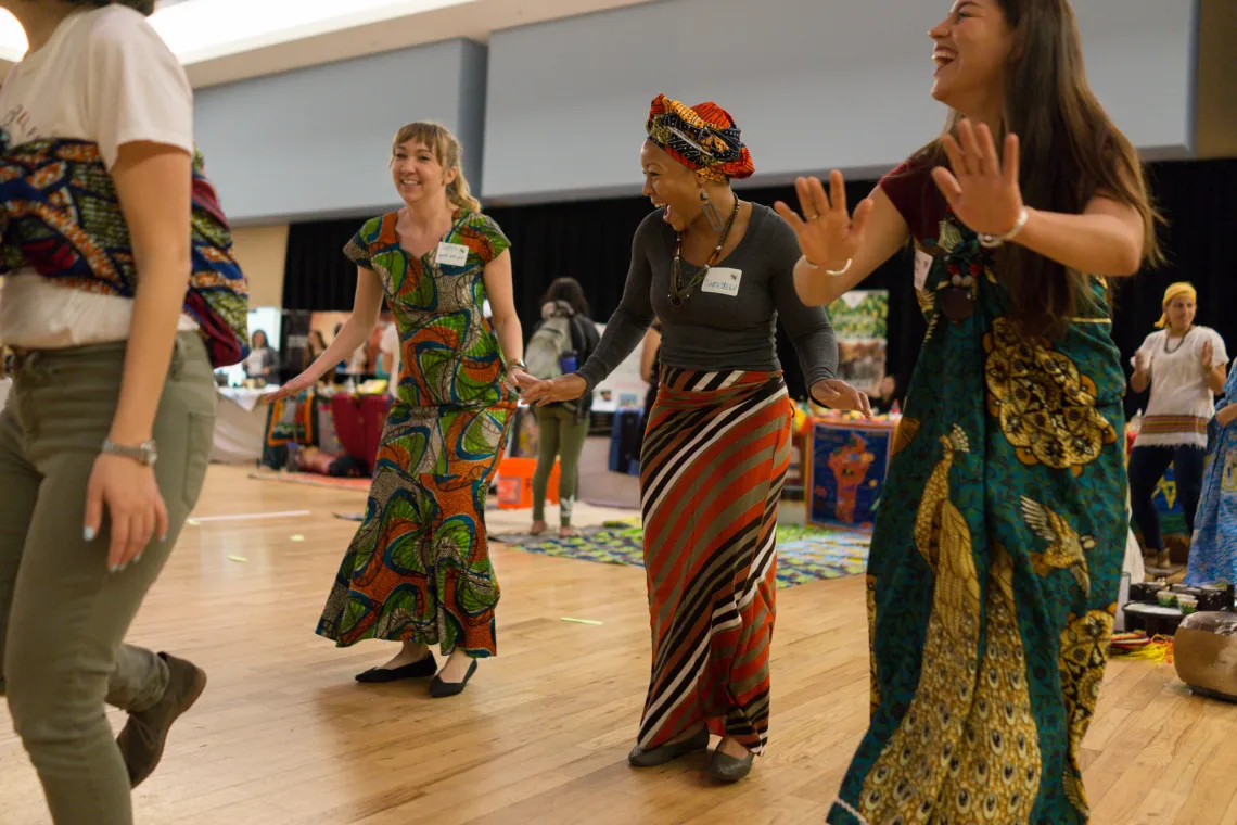Fellows dancing in African traditional clothing at Peace Corps Fair