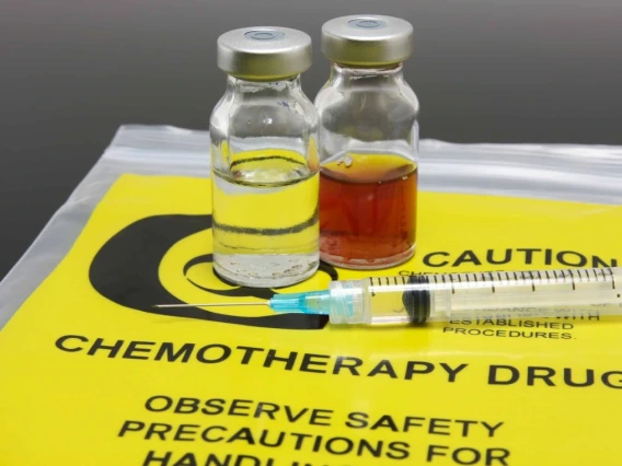 Image of syringe, two vials and a yellow chemotherapy waste bag
